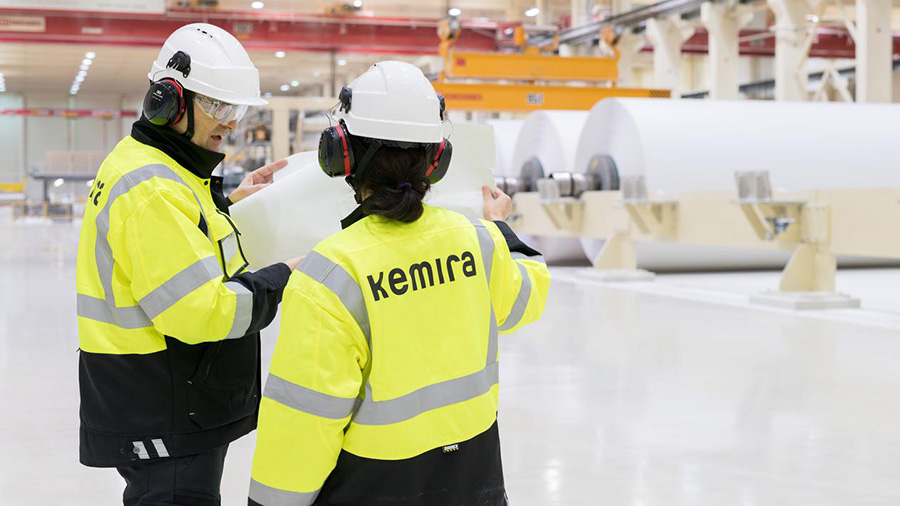 Two people discussing paper production.